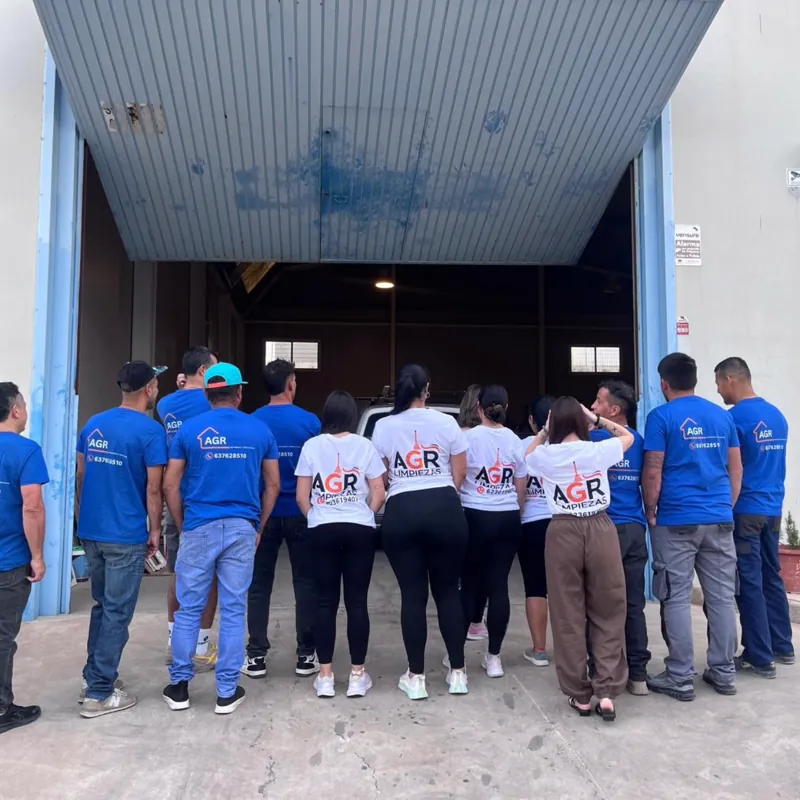 El equipo de AGR de espaldas a la entrada de la nave, con las camisetas azules de reformas y las blancas de AGR Limpiezas