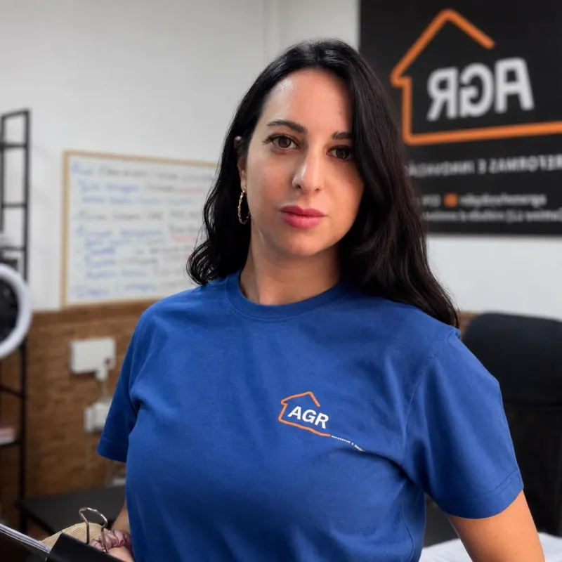 Trabajadora de AGR en la oficina, con el rótulo de la empresa detrás